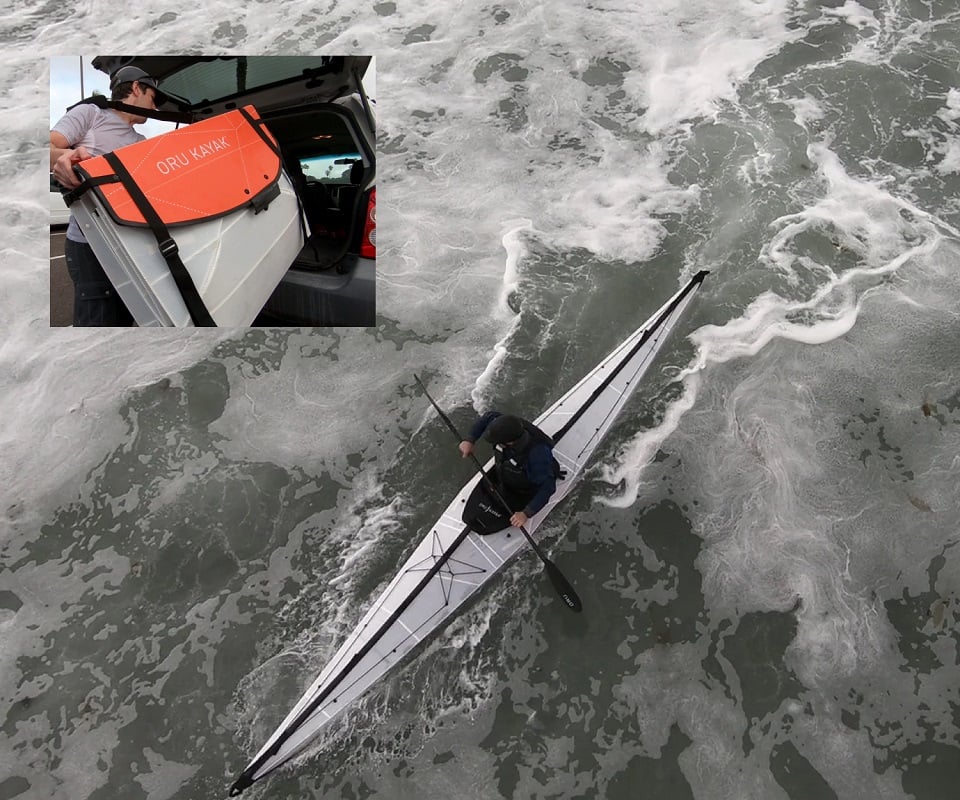 The Oru Kayak Coast XT folding kayak being paddled on open water.