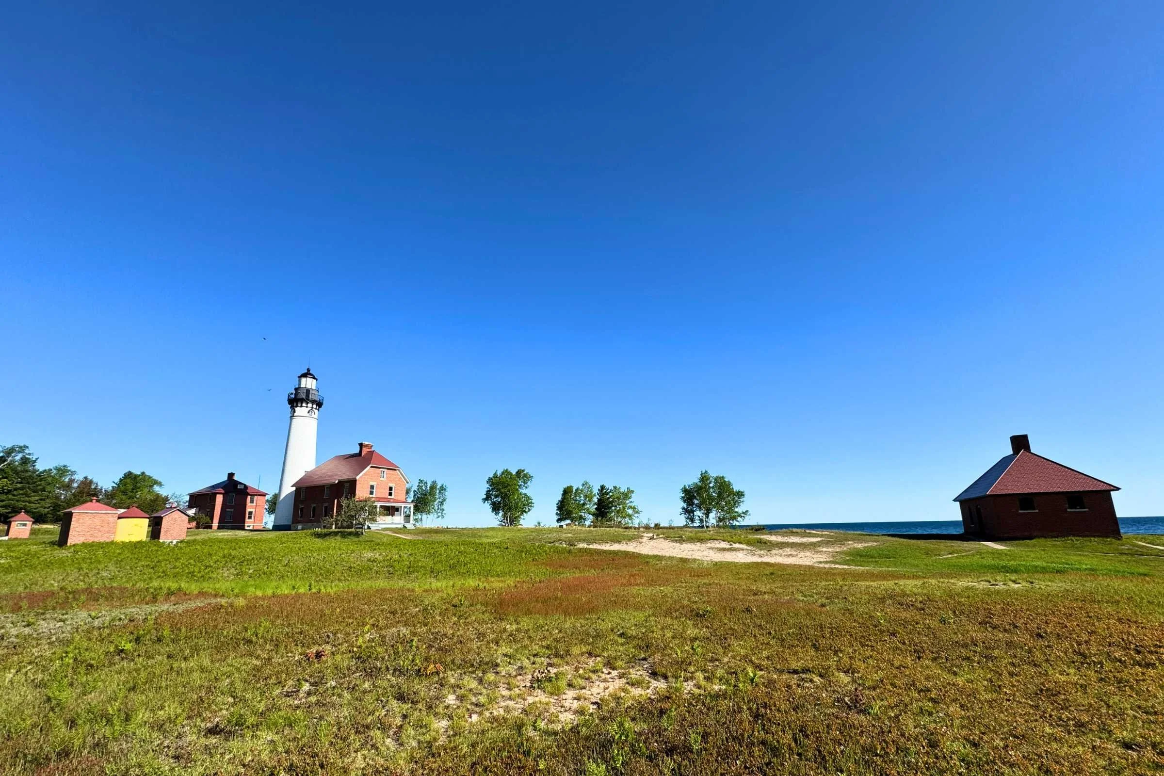 The red and white Au Sable Light Station against a blue sky.