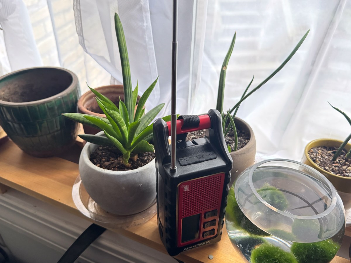 The Midland ER310PRO weather radio sits outdoors with its solar panel tilted toward the sun.