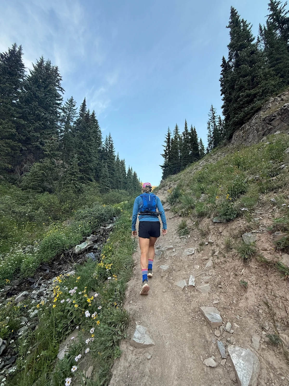 A trail runner without poles moving quickly up the rocky terrain toward Buckskin Pass.