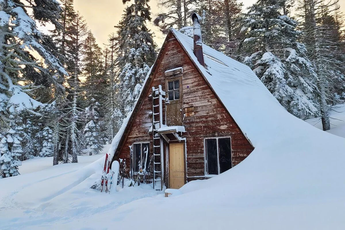 The exterior of Ludlow Hut surrounded by deep winter snow.
