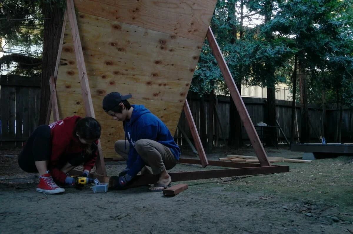 A completed indoor home bouldering wall with several climbing holds installed.