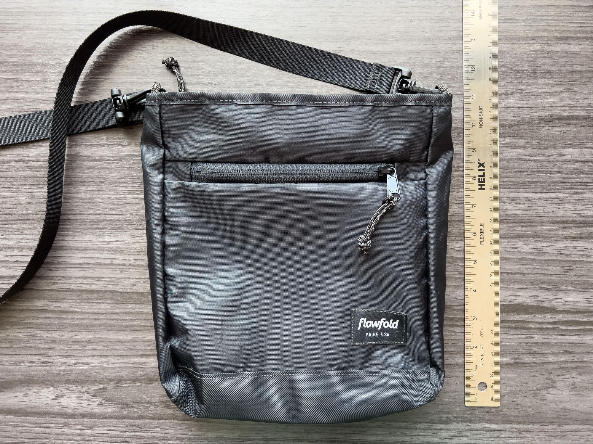A small, tan lightweight crossbody bag designed for carrying outdoor journaling supplies.