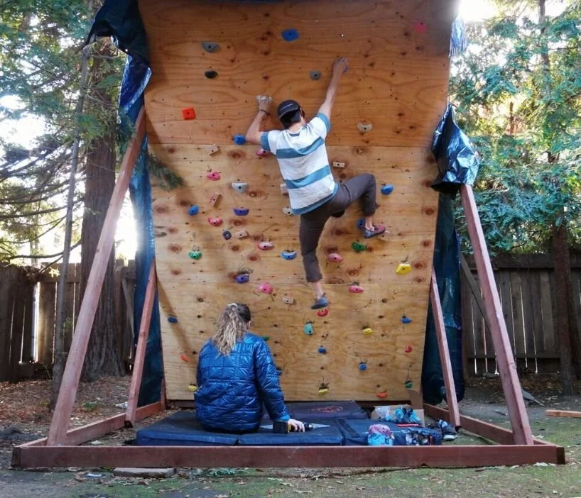 A person climbing on a steep DIY overhanging wooden climbing wall.