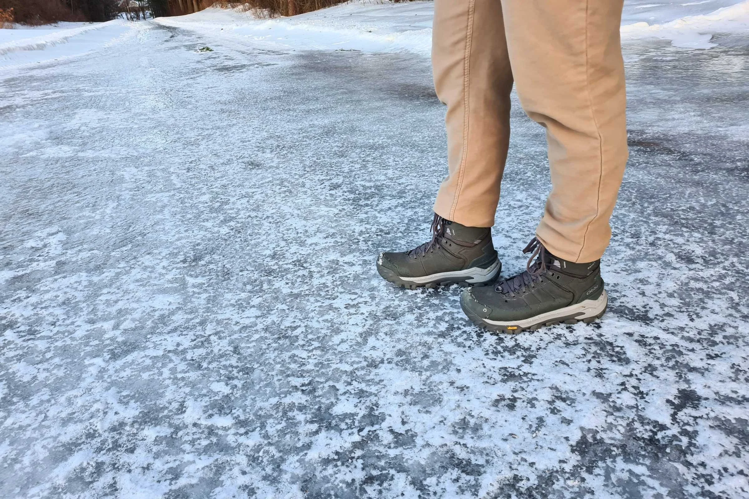 Oboz Bangtail boots performing on an icy, frozen trail surface.