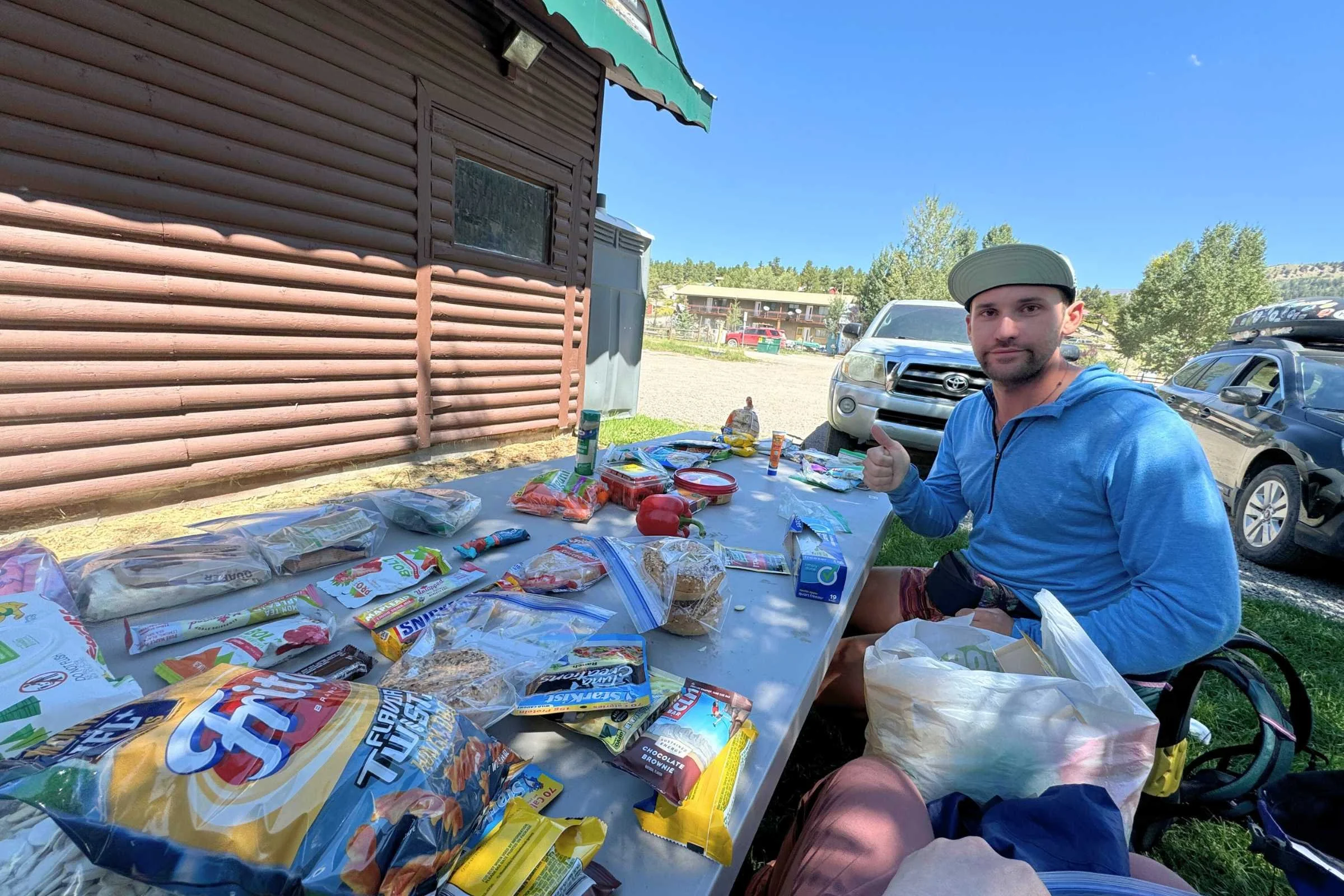 A thru-hiker eating a meal from a titanium pot during a break.