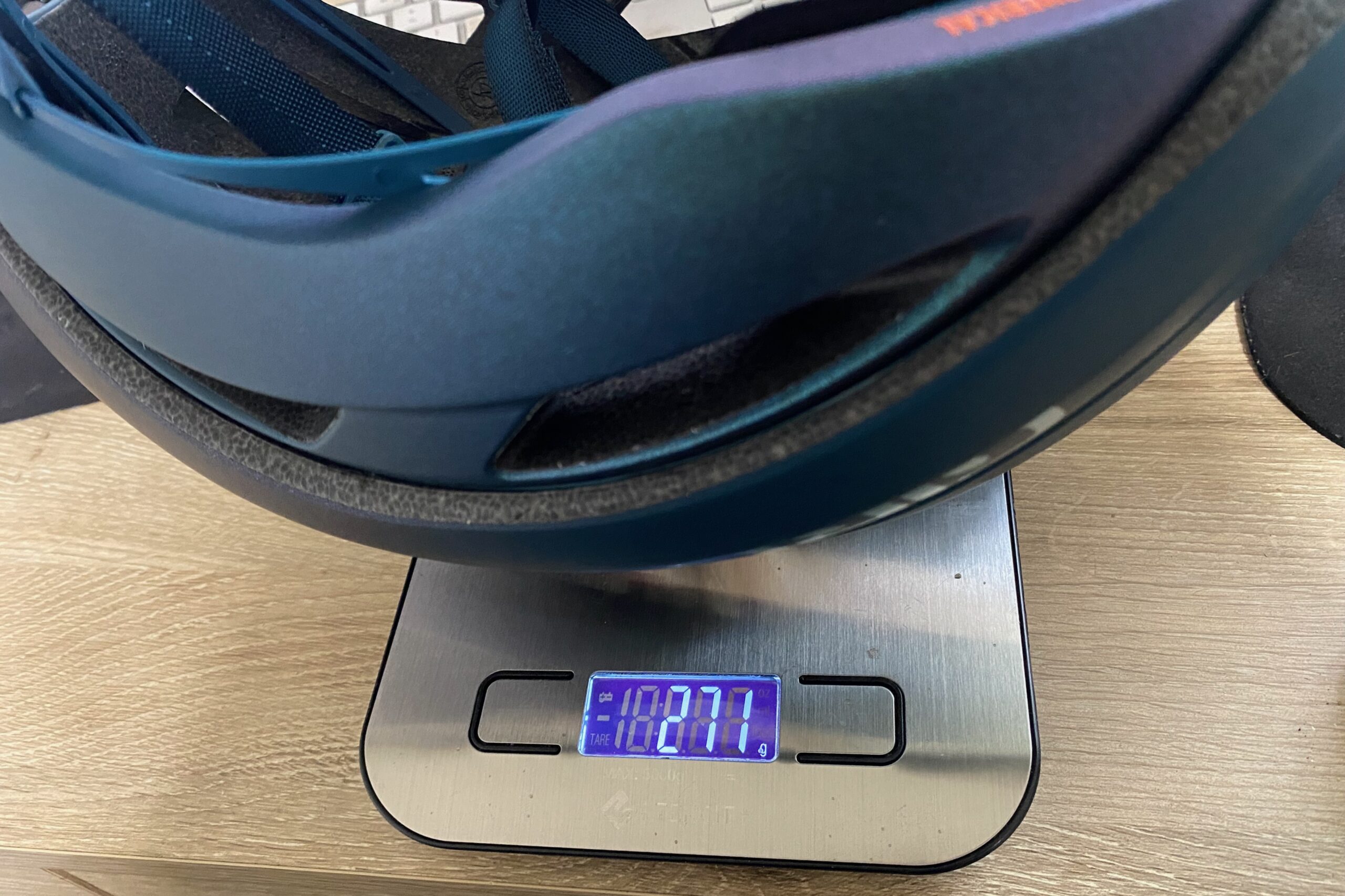 Giro Aries helmet resting on a digital scale showing its weight in grams.