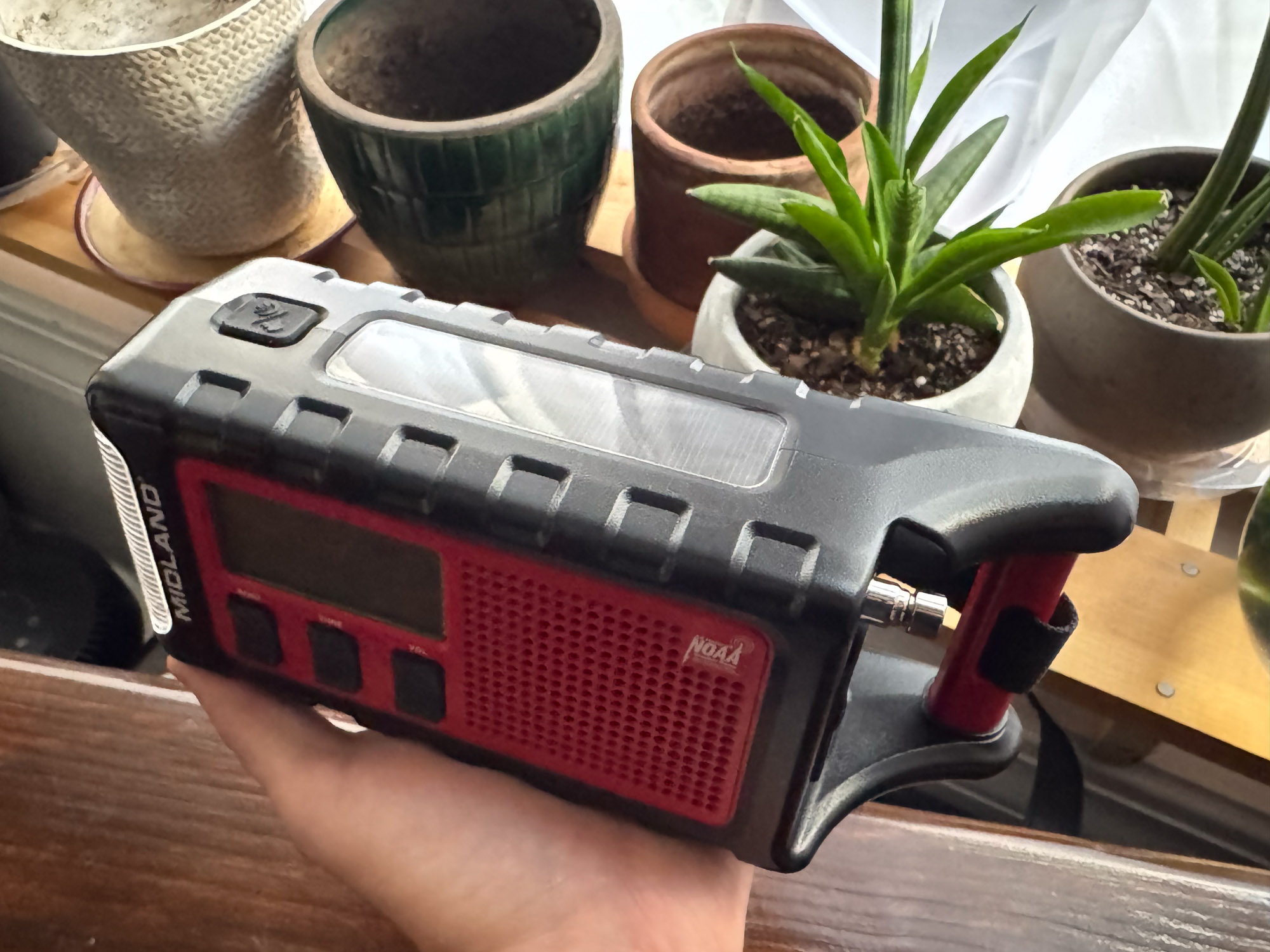 A person holding the ER310PRO to display the top-mounted solar panel.