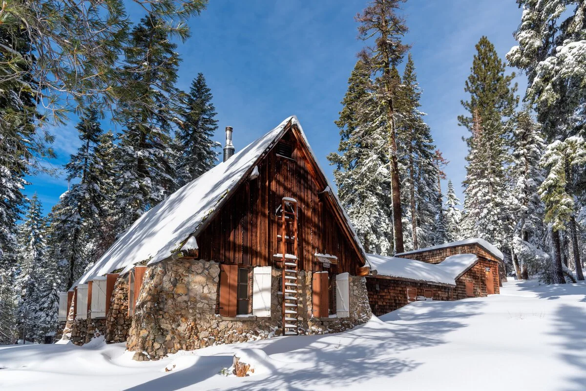 Sierra Club Hutchinson Lodge, a large rustic log building nestled in the snow and trees.