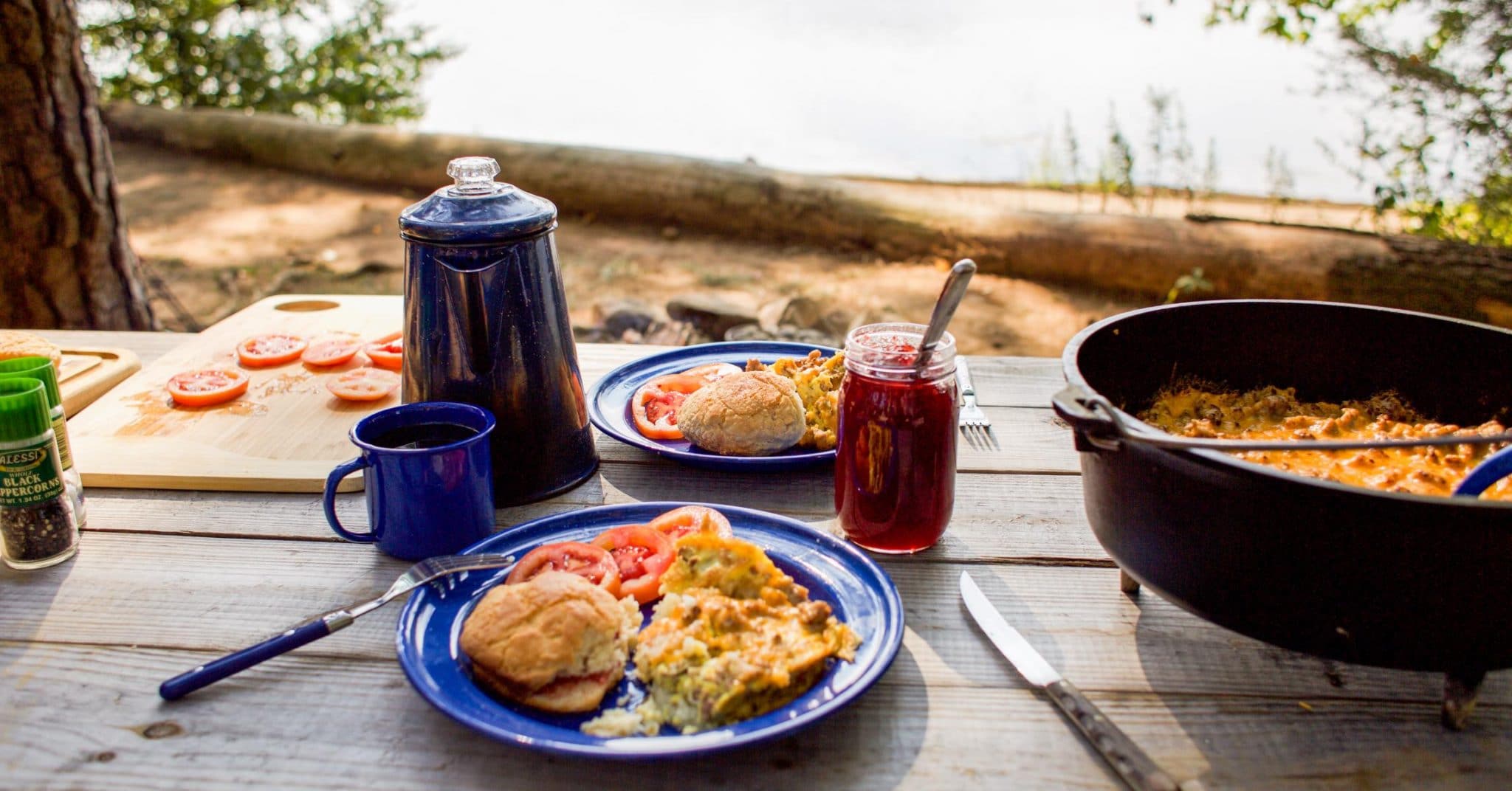 A camping breakfast scene featuring a hearty egg casserole and a cup of coffee