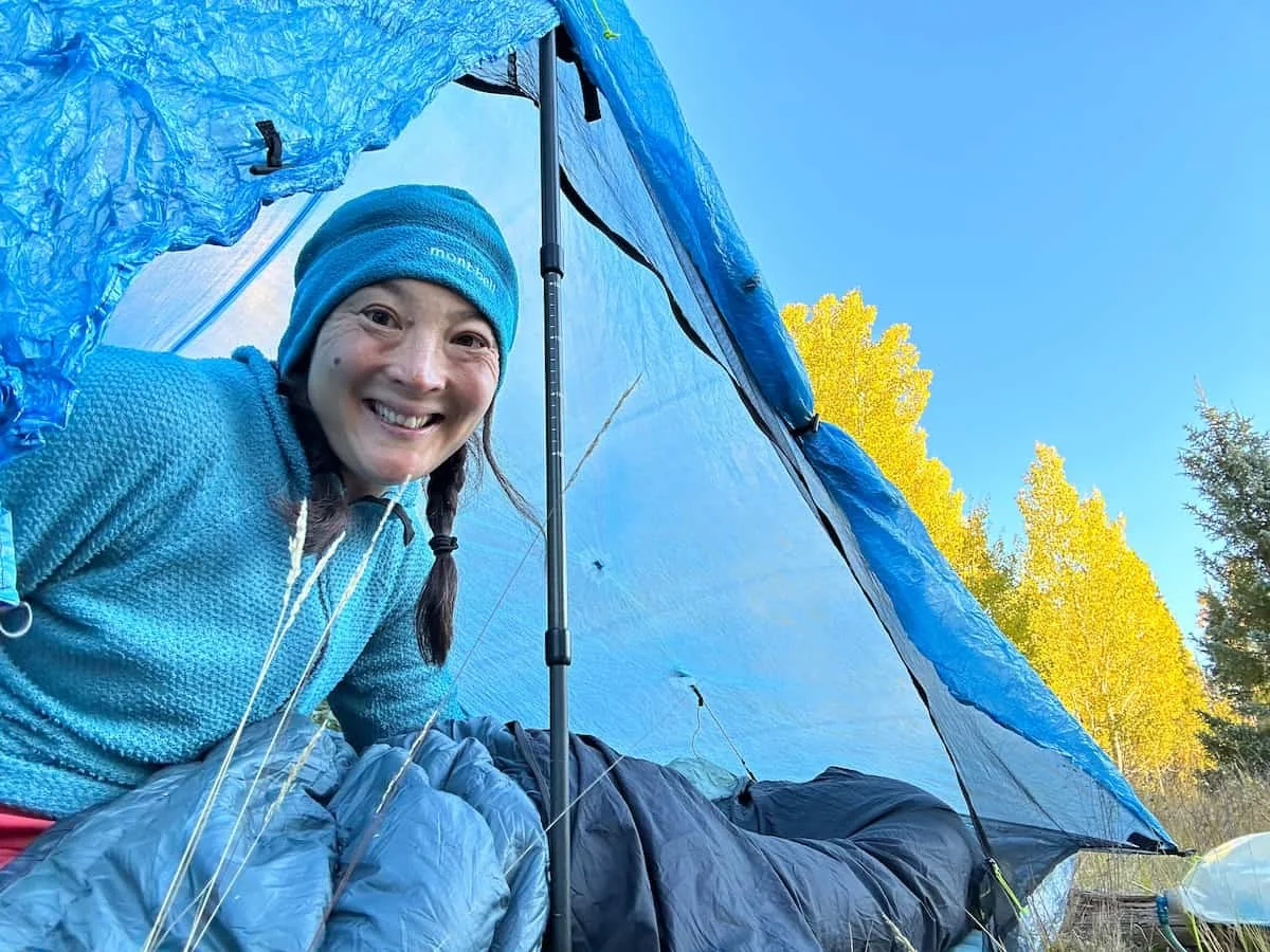 A close-up of a sleeping bag liner being tucked into a technical sleeping bag.