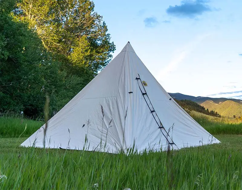 A 10oz pyramid-style range tent featuring a round metal stove jack on its side.