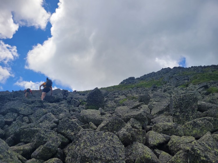 Large boulders and jagged rocks forming a steep trail up Mount Adams.