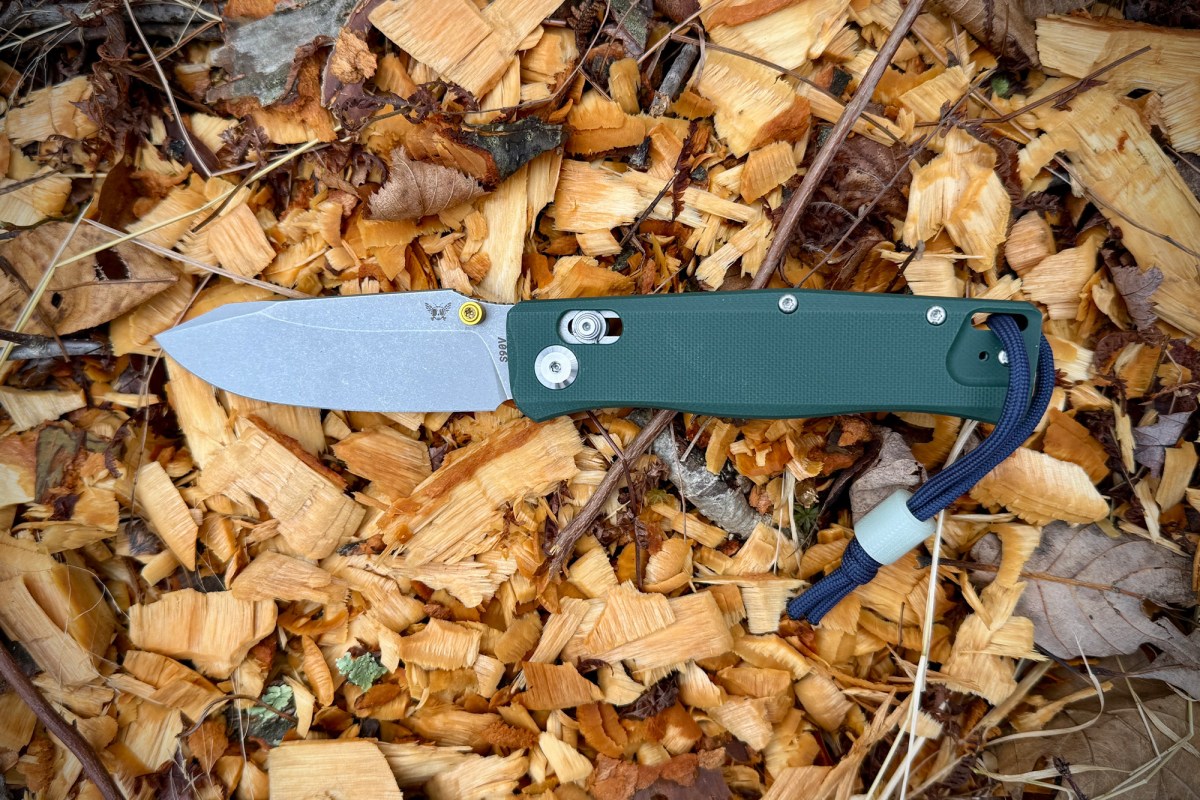 The Flytanium BEEF knife blade resting on top of wood shavings from a carving task.