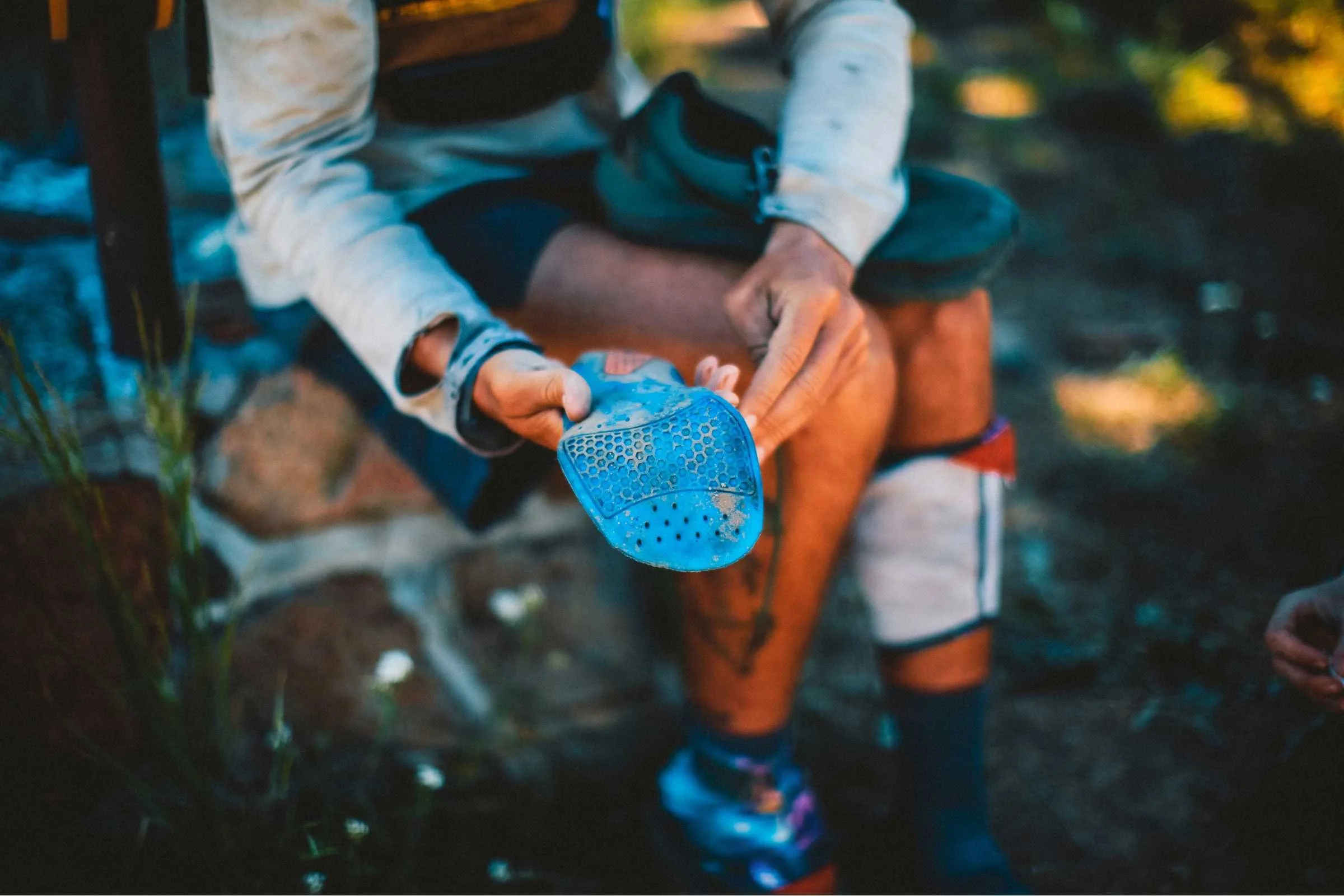 A hiker examining trail runner insoles for potential replacement.