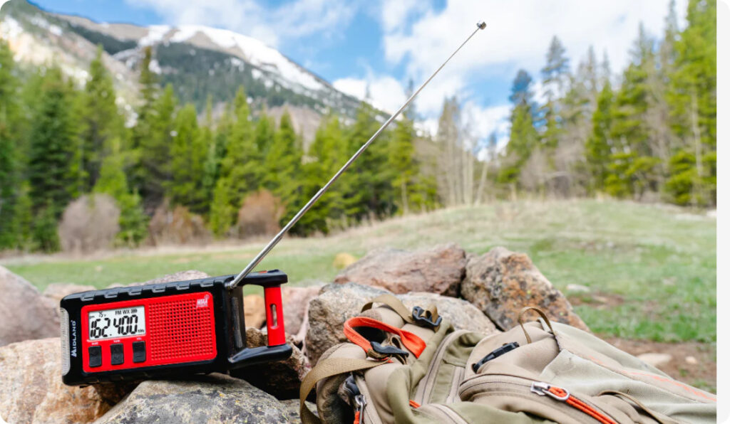 Midland ER310PRO placed in a mountain meadow to signify backcountry utility.